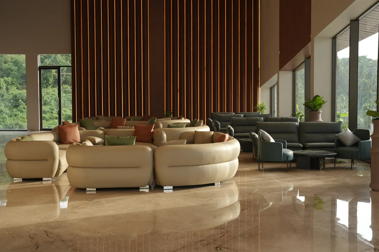 Double-height lounge with a backlit timber slat wall and cream seating opening onto the forested hillside